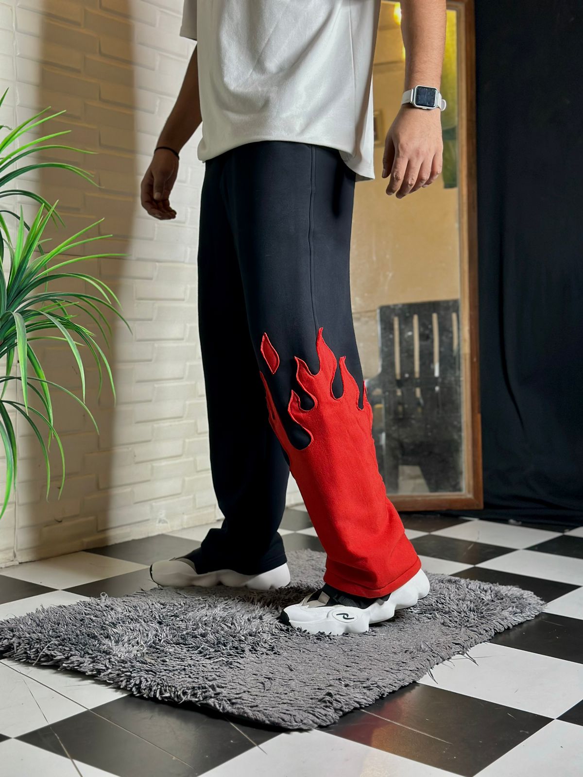 Close-up of red flame embroidery on black cotton Fire Kick Pant

